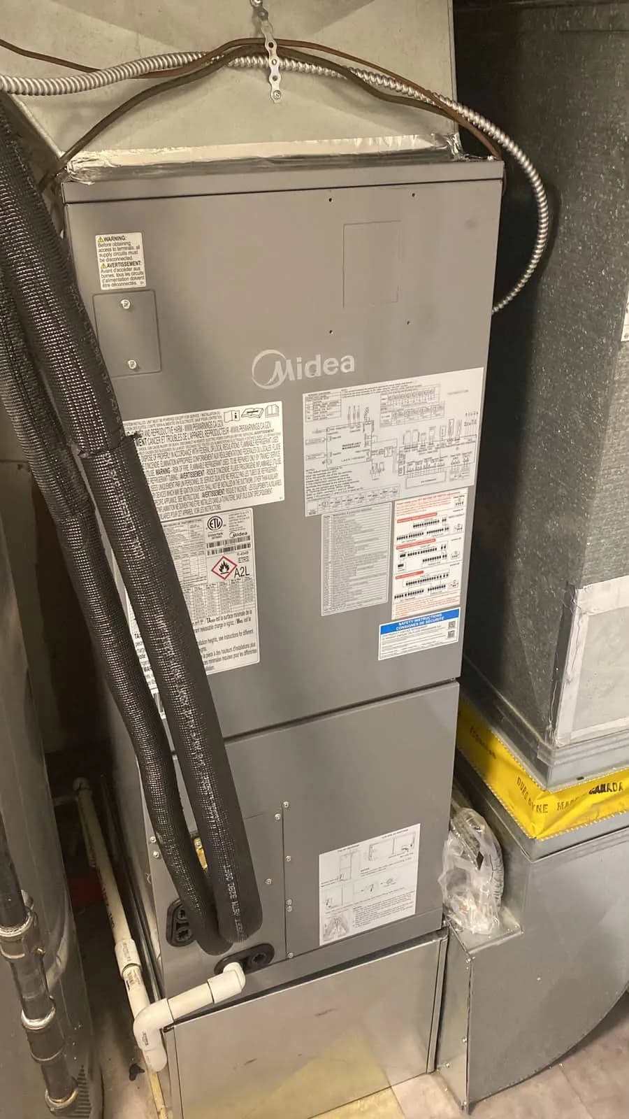 Midea air handler with insulated refrigerant lines in a utility room